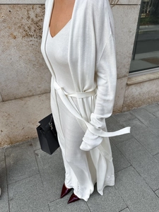 Detailed outdoor shot of a white knitted long cardigan and matching V-neck maxi dress set