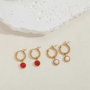 Detail of vintage gold twisted hoop earrings with polished red and marble pendants