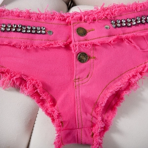 Dettaglio degli shorts in denim rosso rosa con strass scintillanti e orlo a frange