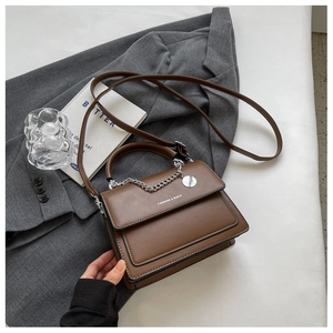 Top view of brown leather crossbody bag with silver chain and adjustable strap