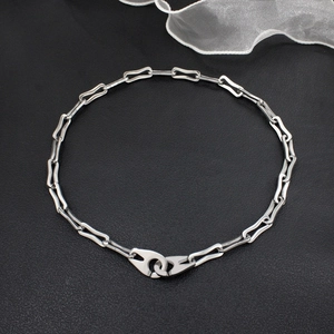 Silver rectangle link chain necklace with modern industrial style on black leather background