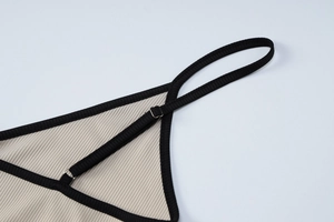 Détail de la boucle en métal réglable et liseré noir sur caraco côtelé beige