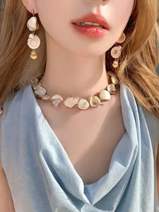 Detail of seashell necklace and earring set on a model for beach vacation style