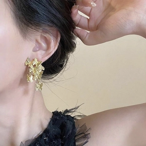 Detail shot of golden vintage butterfly earrings featuring clustered metal design for women