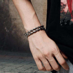 Close-up of men's stainless steel Cuban link bracelet with vintage textured patterns