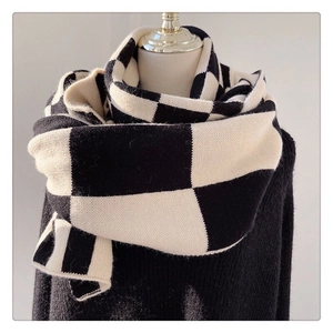 Detail of soft knit texture and classic black and white plaid pattern on winter scarf