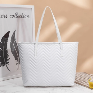 White wavy quilted PU leather tote bag displayed on marble surface with dual shoulder straps
