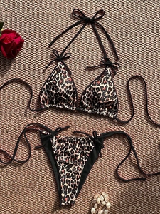 Flat lay of a leopard print bikini set with triangle top and side-tie bottoms on a mat