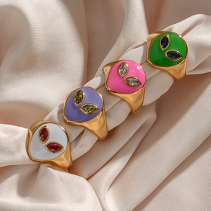 Gold-plated stainless steel rings with colorful alien motifs on elegant silk background