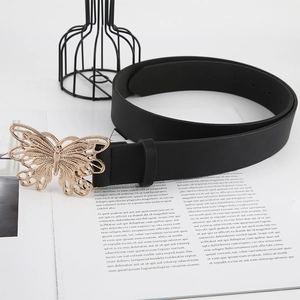 Macro detail of the golden butterfly buckle and premium black leather belt texture