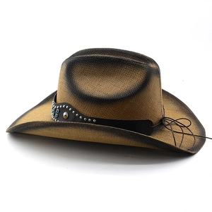 Detail of western straw cowboy hat featuring studded leather band and blue stone accents