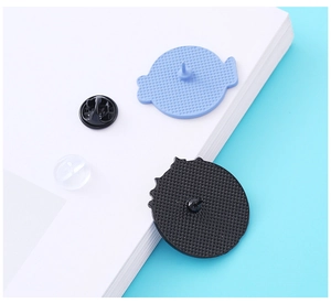 Detail view of round metal pin backs with butterfly clasp and rubber clutch closure