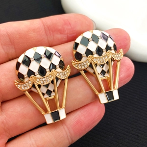 Vue macro de boucles d'oreilles montgolfière avec émail et strass brillants décorés