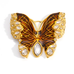 Detailed macro view of an 18k gold butterfly pendant featuring amber resin and crystals