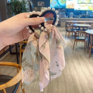 Floral chiffon scarf scrunchie with pearls and rose patterns shown in a hand-held view