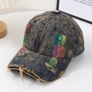 Distressed denim baseball cap with vintage graffiti patchwork and frayed detailing