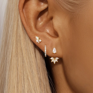 Macro shot of gold S925 silver earring set with marquise and teardrop zircon on ear
