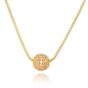 Detail of a golden box chain necklace with a spherical pendant set with pink zircon stones