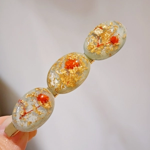 Exquisite 8cm resin hair clip featuring dried red flowers and golden foil accents