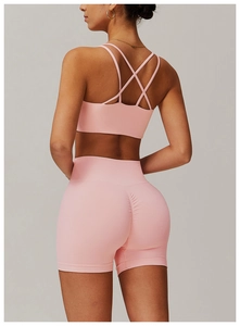 Vue arrière d'un ensemble de yoga rose clair avec brassière croisée et short taille haute