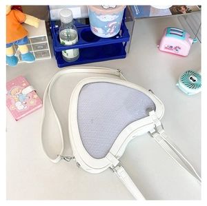 Detail of heart-shaped mesh window on cream PU leather ita bag for badge display