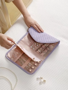 Bolso organizador de joyas de viaje portátil con rollos de anillos y compartimentos.