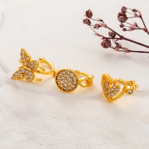 Detailed view of three gold-plated butterfly and heart cuff earrings with cubic zirconia