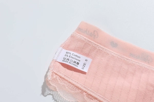 Detailed view of the fabric label showing 95% cotton material and size S on pink lace thong