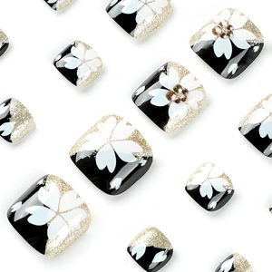 Short square press-on toenails with black base, white cherry blossoms and gold glitter