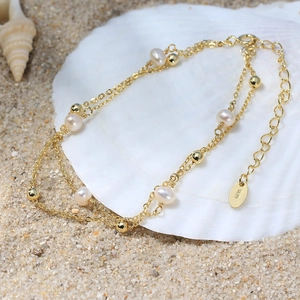 Detail of S925 silver double-layered pearl bracelet displayed on a seashell at beach