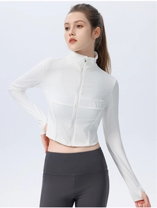 Detail of white ribbed cropped yoga jacket featuring high collar and thumbhole sleeves