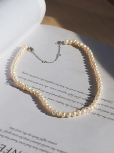 Detail of freshwater pearl necklace on an open book page with elegant soft lighting