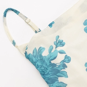 Detalle de tirantes ajustables y tejido de malla floral azul en el vestido corto