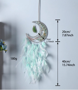 Detail of moon dream catcher featuring green agate stones and natural feathers hanging decor