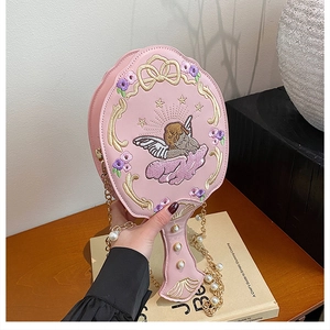 Detail of pink hand mirror crossbody bag with cupid embroidery and pearl chain