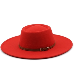 Detail of red wool felt fedora hat featuring a classic brown leather buckle band accent