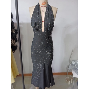 Detail of a black halter neck evening dress with sparkling rhinestones and deep V-neckline