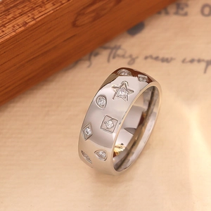 Macro shot of silver stainless steel wide band ring with star and teardrop zircon inlays