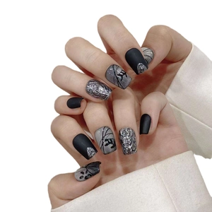 Short square press-on nails featuring matte black and metallic silver cat-eye designs