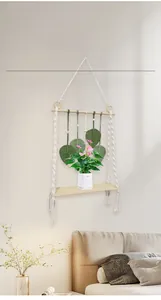 Detail of bohemian woven wall shelf featuring green leaf accents and a wooden base