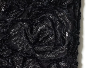 Makroaufnahme von 3D-Rosenstoff mit Pailletten und Mesh am schwarzen Oberteil