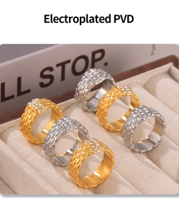 Detalle de anillo ancho chapado en PVD con textura trenzada y doble fila de cristales