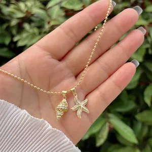 Detailed close-up of gold 18K plated necklace with seashell and starfish zircon charms