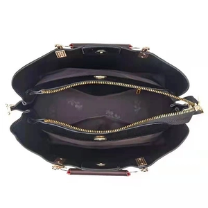 Top view of black handbag interior showing multi-compartment layout and golden hardware