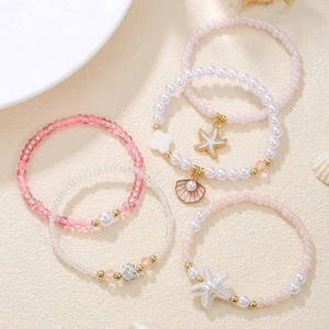Detail view of 5-piece beach beaded bracelet set with starfish and shell charms