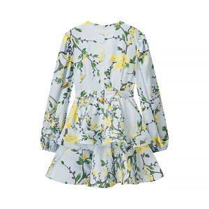 Detail of light blue floral dress with tiered ruffles and intricate yellow bird prints