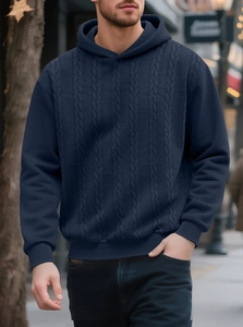 Close-up of men's dark blue cable knit hoodie featuring detailed ribbed cuffs and texture