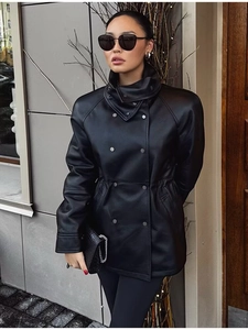 Détail du design à double boutonnage et du cordon à la taille de la veste en cuir noir