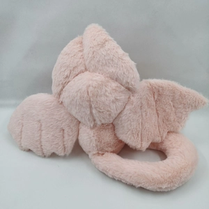 Detailed close-up of a pink plush rabbit with wings and coiled tail on grey background