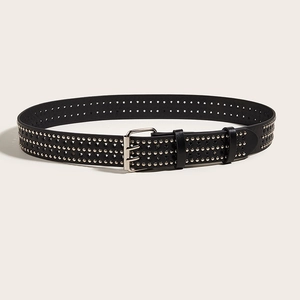 Détail d'une ceinture punk en cuir noir avec rivets en étoile et boucle à double ardillon